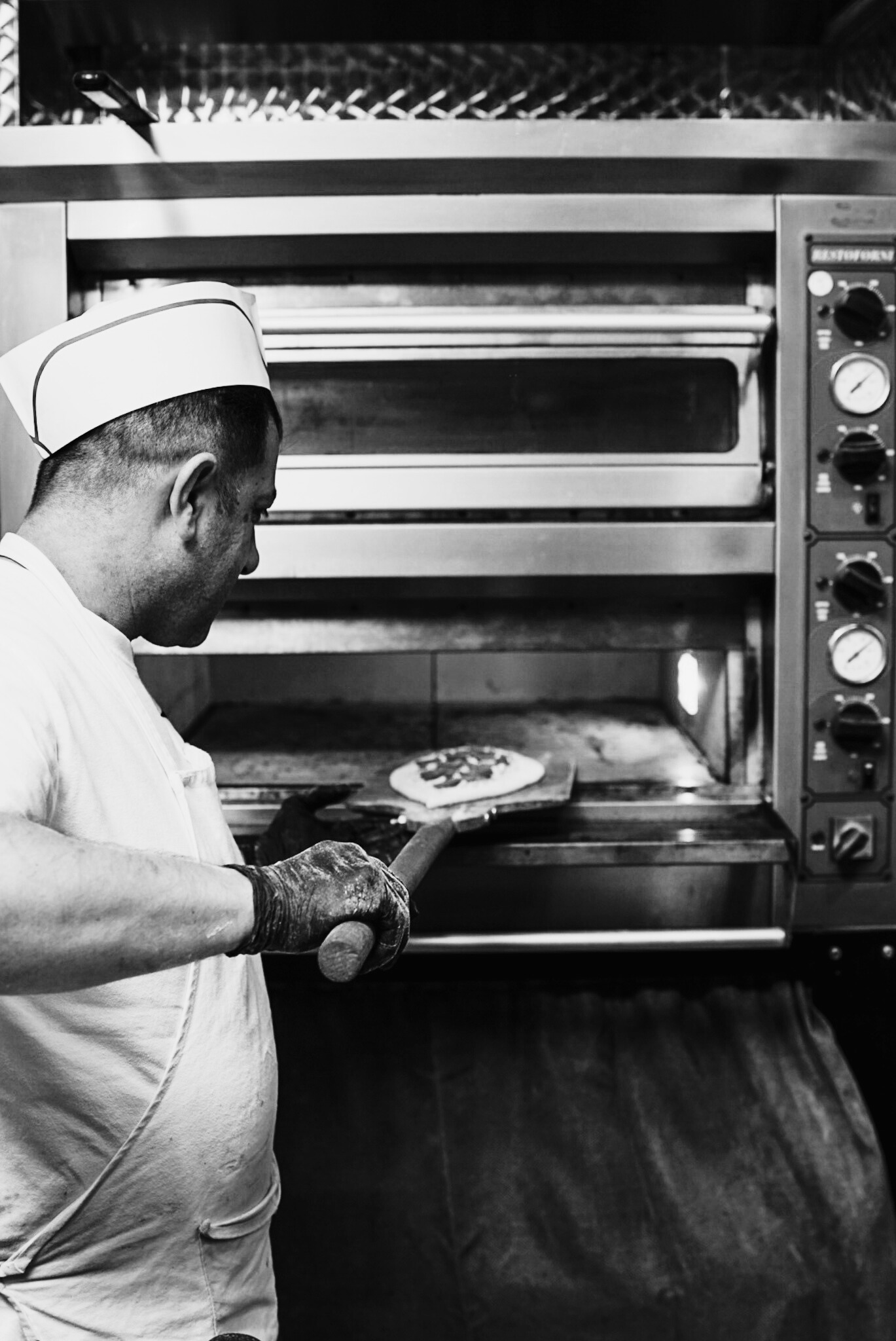 Thin pizza coming out from the oven